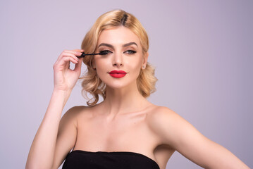 Fototapeta premium Woman shaping eyelashes. Woman eye with beautiful eyelashes. Shaped long lashes. Paint eyelashes. Girl contouring lashes on isolated studio background.