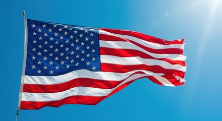 Obraz premium Vibrant american flag waving against clear blue sky captures patriotism and freedom