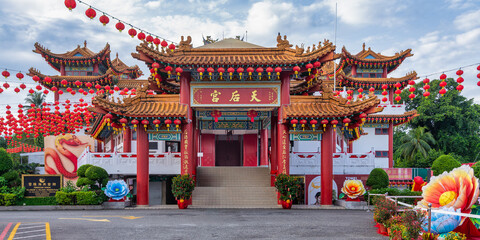 Naklejka premium Thean Hou Temple, in Kuala Lumpur, Malaysia, showcases intricate architecture surrounded by bright red lanterns and colorful floral decorations