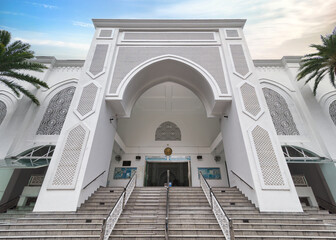 The grand entrance of Al-Bukhari Foundation Mosque in Kuala Lumpur, Malaysia, set amid lush greenery, with intricate Islamic architecture, creating a serene space for reflection and prayer