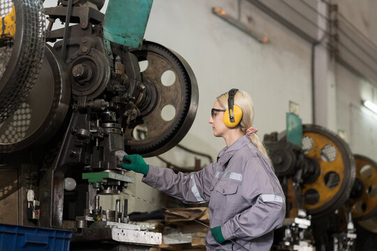 Engineer woman, factory and lather machine. Engineer woman at work in the industry factory, working with CNC machine. Woman worker working with lathe machine