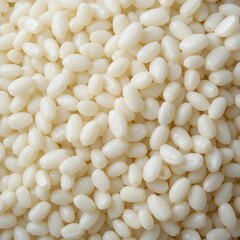 A close-up of glutinous rice grains, showcasing their sticky texture and pearly white color, on a clean white background.