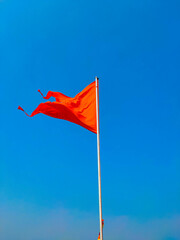 saffron colour flag with blue sky background.