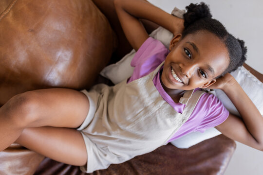 Smiling girl relaxing on couch at home, enjoying leisure time
