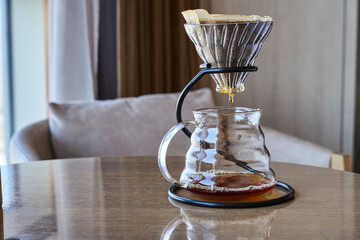filtered coffeepot on table beside cozy sofa