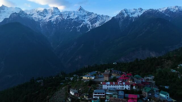 Aerial drone shot of Kalpa in winter, blanketed in snow with the striking Kinner Kailash range.
