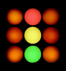 A square set of nine chicken eggs. Six red at the edges. The central ones are painted in the colors of a traffic light (red, yellow and green).