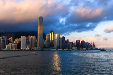Fototapeta premium The view from Victoria Harbour and the skyline of skyscrapers on Hong Kong Island, at sunrise in Hong Kong of China