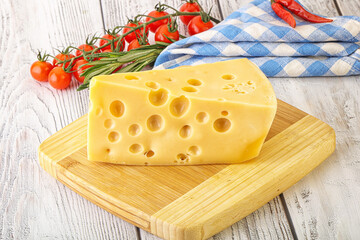 Maasdam cheese piece over board