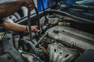 Serpentine belt replacement service in garage shop.