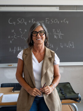 Smiling Mature Female Teacher Looking at the Camera in the Classroom
