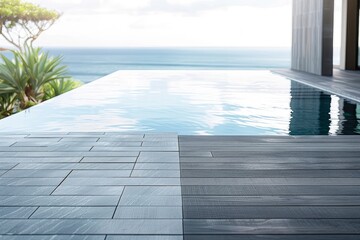 Modern infinity pool overlooking the ocean, with sleek tiles and serene surroundings in daylight