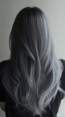 Obraz premium Long silver hair cascading down the back of a person in a softly lit interior space, showcasing a unique hairstyle that draws attention
