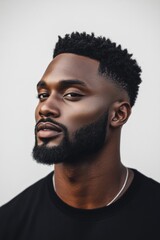 Fototapeta premium Portrait of a confident young man with a stylish haircut and well-groomed beard showcasing attitude in a modern urban setting