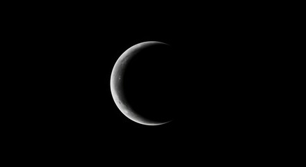 Naklejka premium Crescent moon against black sky nighttime astronomy scene