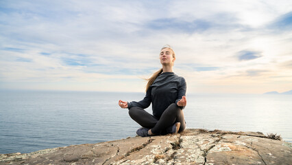 Girl, meditation and yoga by the sea ocean. Young woman in lotus pose in nature. Fitness, zen,...