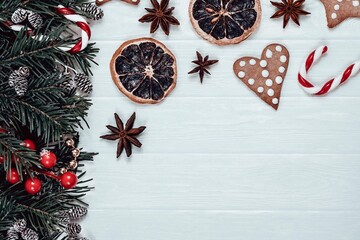 Christmas atmospheric flat lay. Tradition gingerbreads, candy cane, anise stars, dry orange slices...