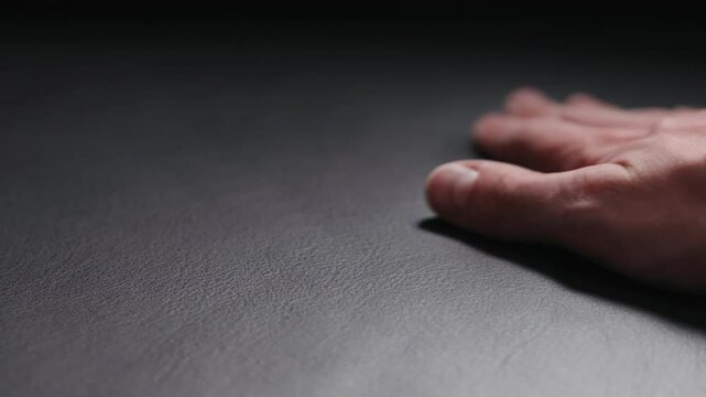 Slow motion man hand touching soft leather cushion