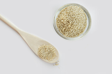 Sesame bowl on a white background. Sesame seeds in a wooden spoon, isolated on a white