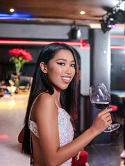 Woman is holding a glass of red wine. Bar, Restaurant and beverage, Night club concept.