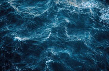 Turbulent ocean waves.  Deep blue water surface with foamy white crests.  Strong movement and texture