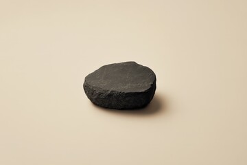 Fototapeta premium A single dark rock sits on a simple neutral background