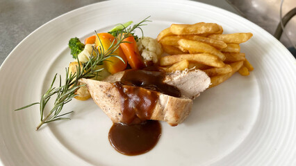 Photoshoot of delicious grilled chicken with sauce, fried fries and salad. Barbeque delicious with potatoes and vegetables. 