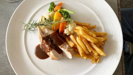 Photoshoot of delicious grilled chicken with sauce, fried fries and salad. Barbeque delicious with potatoes and vegetables. 