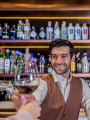 Bartender giving glass of wine to woman customer at bar counter .