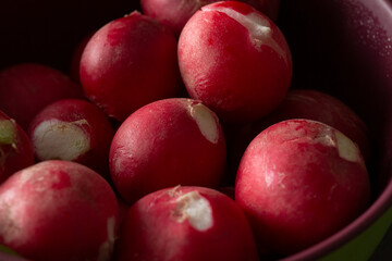 A closeup view of a bowl of red radishes.