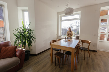 Woman drinking tea and eating a cake in her kitchen