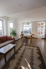 Woman drinking tea and eating a cake in her kitchen
