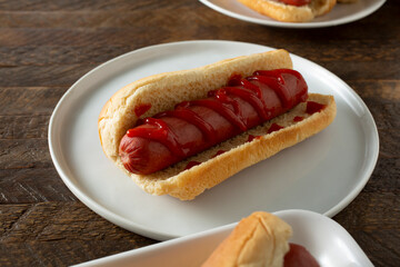 A view of a hot dog topped with ketchup.