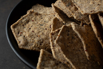 A closeup view of a pile of quinoa black bean tortilla chips.