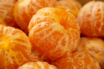 A closeup view of a pile of peeled mandarins.