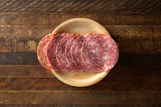 A top down view of a stack of Calabrese salame on a plate.