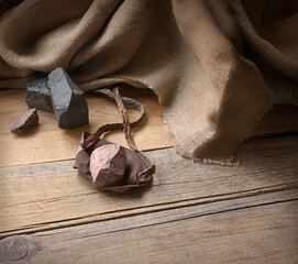 An antique leather sling lies on wooden desk