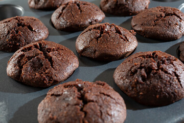 A closeup view of a muffin pan of flax seed chocolate brownies.