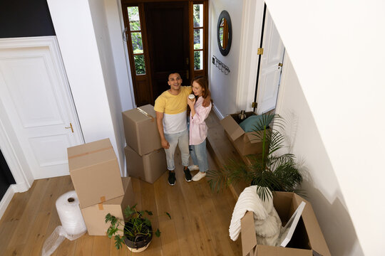 Young diverse couple unpacking boxes in new home, smiling and feeling excited