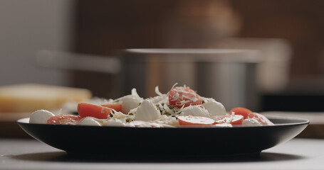 sprinkle penne with mozzarella, tomatoes and pesto with aged grated cheese