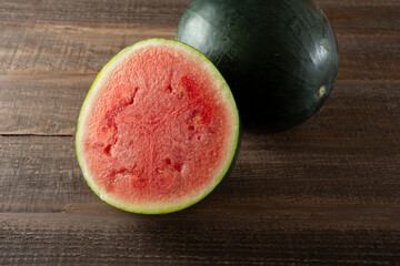 A view of black diamond watermelon, featuring one that is halved.