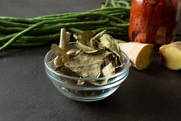 A view of a small bowl of dried kaffir lime leaves.
