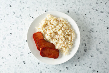A top down view of a plate of pork luncheon meat and garlic rice.