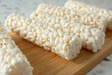 A closeup view of several crunchy rice rolls, on a wood board.