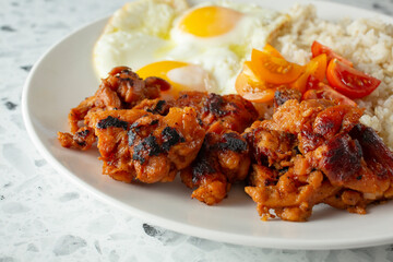 A closeup view of a chicken tocino breakfast plate.
