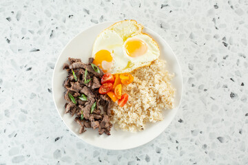 A top down view of a beef tapa breakfast plate.