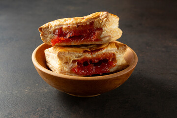 A view of a stack of guava strudel pastries in a wood bowl.