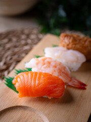 Japanese sushi salmon, shrimp, Squid, and sweet egg (tamago) on wooden plate.