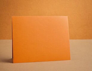 Fototapeta premium Blank orange greeting card on a warm, textured background, perfect for personalization and festive occasions.