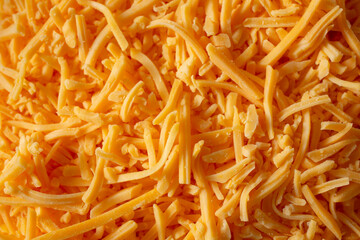 A top down view of a layer of shredded cheddar cheese, as a background.